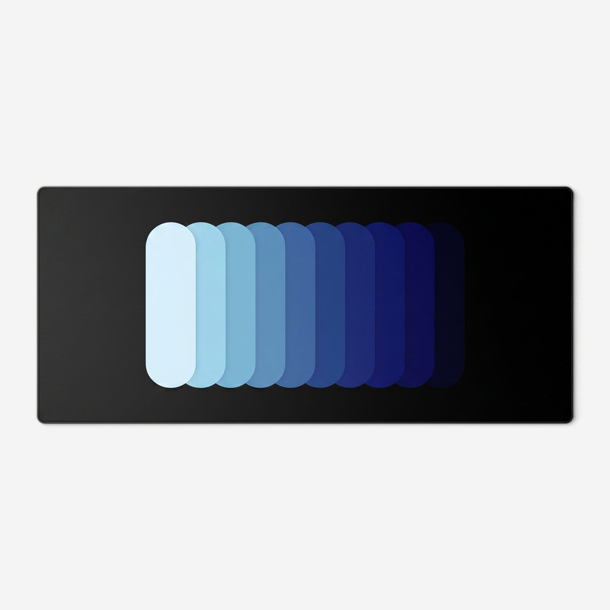 Gradient Capsule Desk Pad in Blue, with overlapping rounded bars on a black background