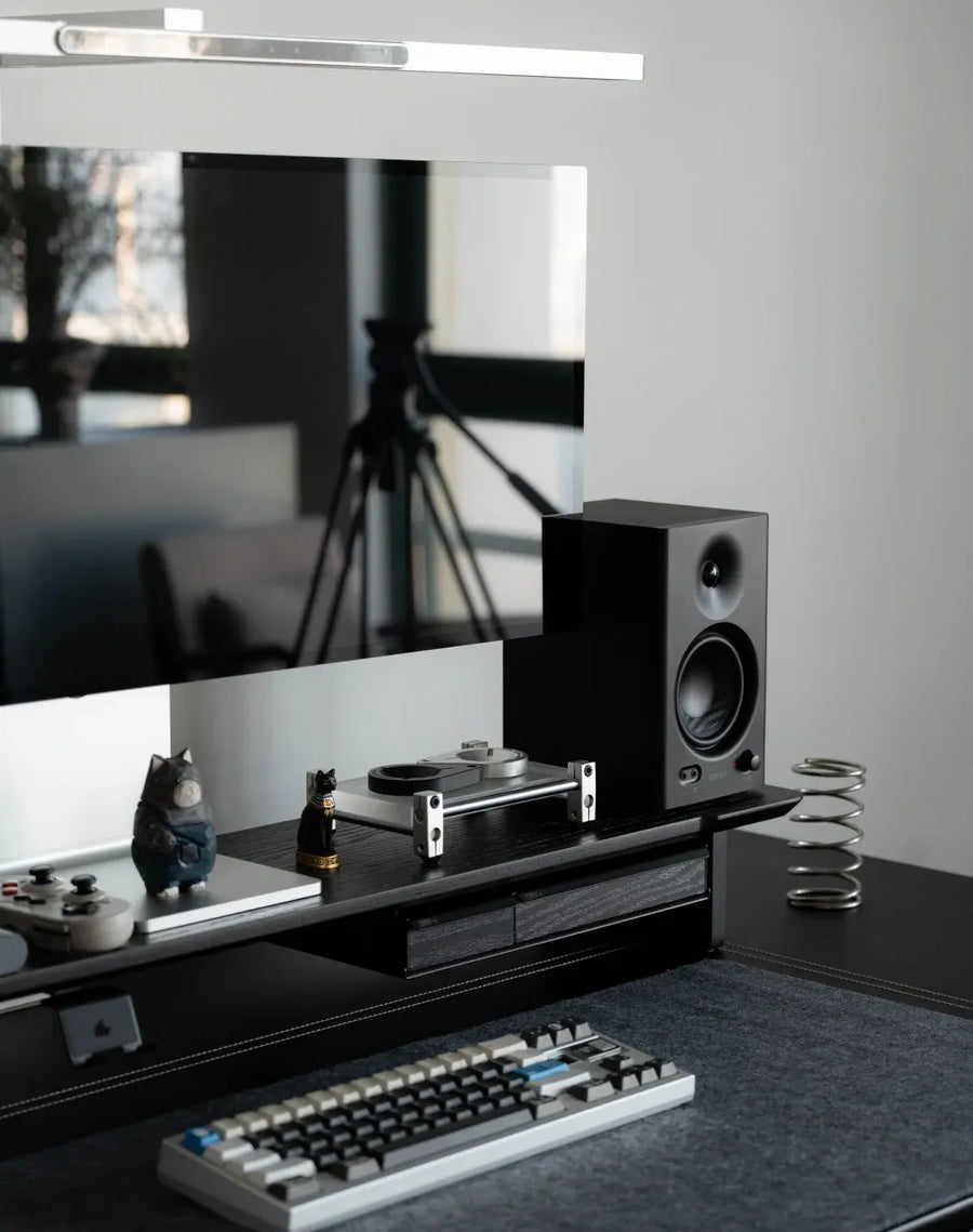 Lift the display onto a riser so the keyboard and desk mat stay clear.