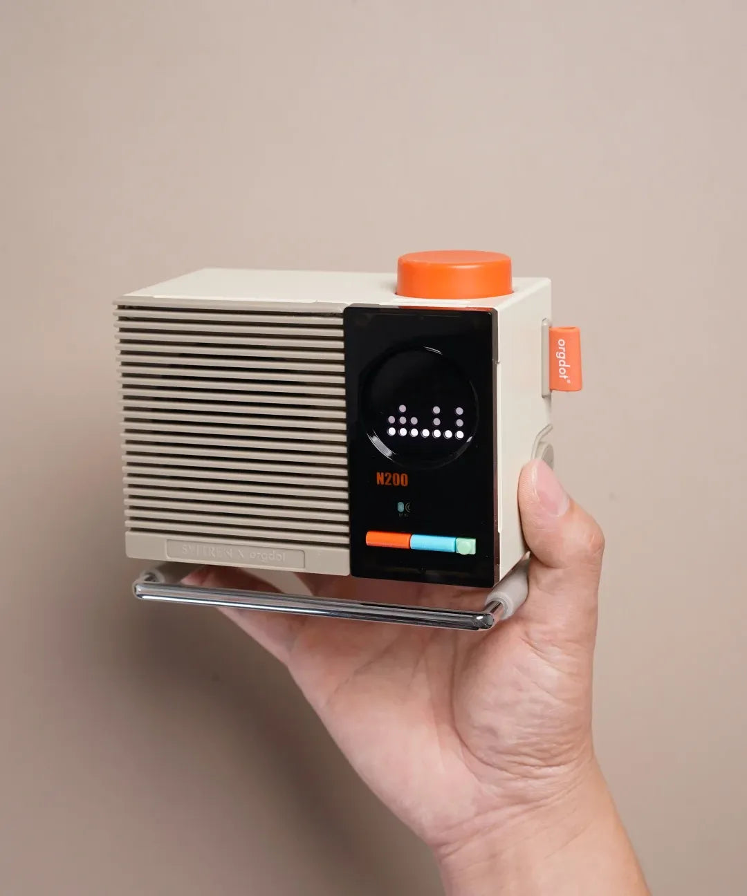 Hold the N200 to see its compact size and the orange knob that anchors the design.