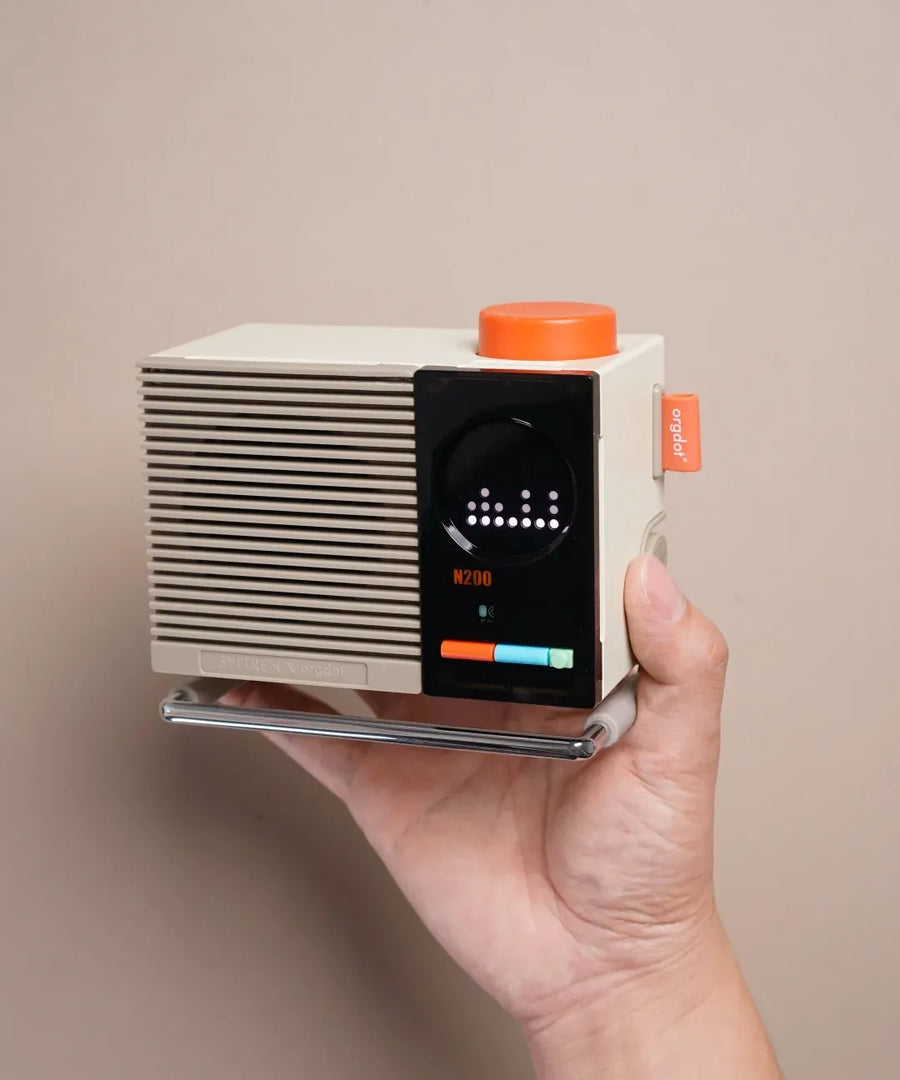 Hold the N200 to see its compact size and the orange knob that anchors the design.