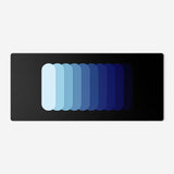Gradient Capsule Desk Pad in Blue, with overlapping rounded bars on a black background