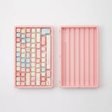 Pink ABS keycap storage box shown open with demonstration keycaps; keycaps not included